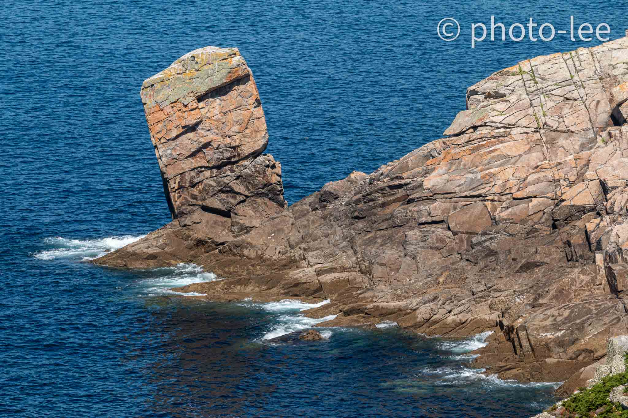 Ein hoher Steinfels steht einsam an der Küste